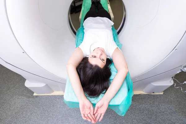 stock image beautiful woman lying on ct scanner bed during tomography test in hospital.