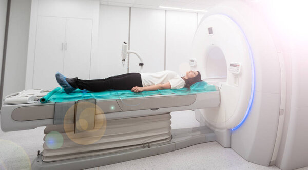 Пациентка, проходящая МРТ - магнитно-резонансную томографию в больнице. Медицинское оборудование и здравоохранение
.