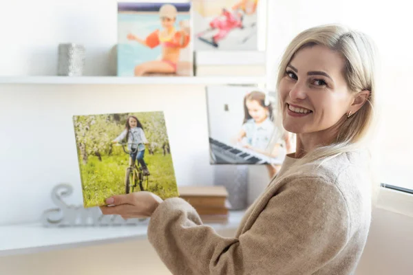 年轻女子在墙上挂着一幅画布油画 — 图库照片