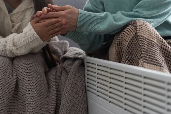 家庭の電気ヒーターの近くの子供の手を暖める クローズアップ — ストック写真