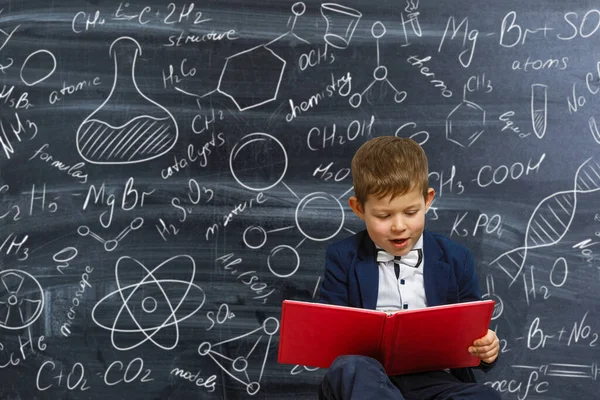科学的な式や図と黒板の背景に学校の制服で賢い男の子の肖像画 賢い子だ — ストック写真