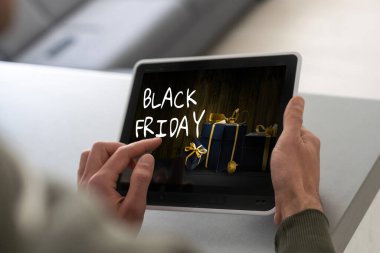 Adam tablet bilgisayar kullanıyor ve Kara Cuma 'yı seçiyor