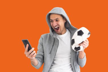 Deforme olmuş bir top ve akıllı bir telefonla futbol fanatiği..