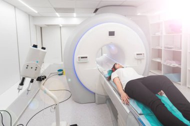 Modern hastane laboratuvarında tıbbi tomografi ya da MRI taraması. Radyografi bölümünün içi. Beyaz odada teknolojik olarak gelişmiş ekipmanlar var. Manyetik rezonans tanılama makinesi.