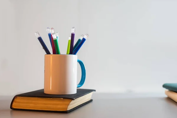 book and a cup with pencils.