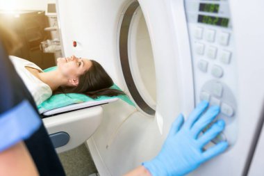 Bilgisayarlı tomografi tarayıcısındaki hastayı ameliyat hazırlıkları sırasında gözden kaçıran CT tarama teknolojisi uzmanı. Kadın hasta tomografiye giriyor.