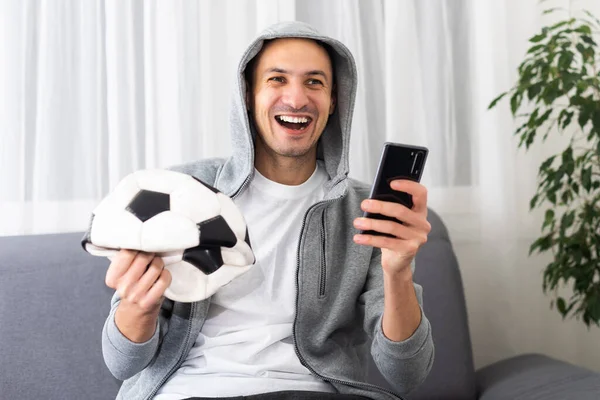 Futbol hayranıyım. Duygusal Adam Stüdyo Arkaplanındaki Top Tutma Takımının Zaferini Kutluyor. Yüksek kalite fotoğraf