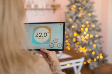 Modern ev akıllı otomasyon uygulaması Noel 'de kadınların elinde tablet ekranda.