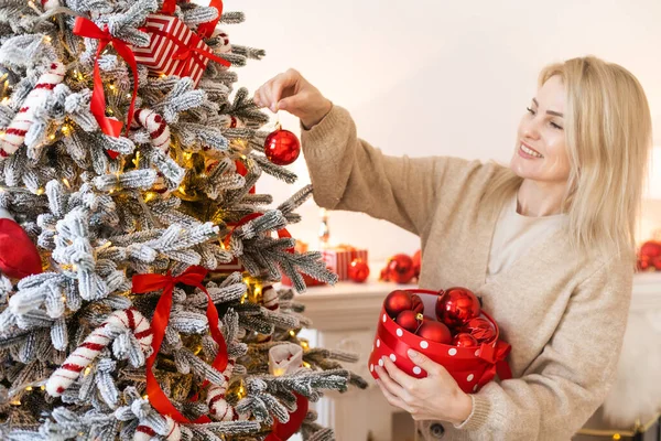 Mas 冬の休日と人々のコンセプト 幸せな若い女性が家でボールでクリスマスツリーを飾る — ストック写真