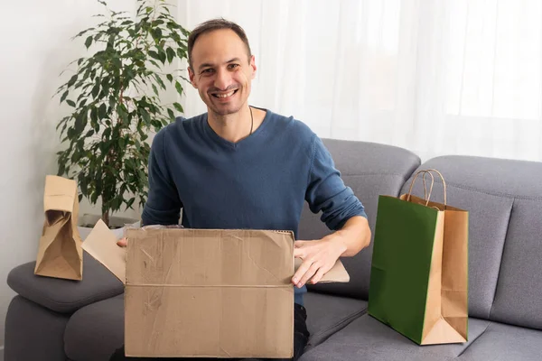 Handsome Young Man Opening Box Parcel While Sitting Sofa Home — Stock Photo, Image