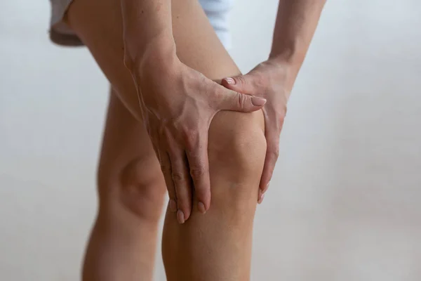 Physical injury of leg, knee, joint - woman holding painful part body