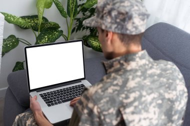 Genç askeri asker adam dikey, arka plan üstünde laptop