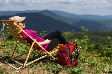 Dağın tepesinde oturan ve yatay geçiş güzel kadın