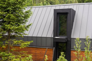 Modern tasarlanmış dış görünüşü büyük yeşil bahçe ve ağaçları olan ev..