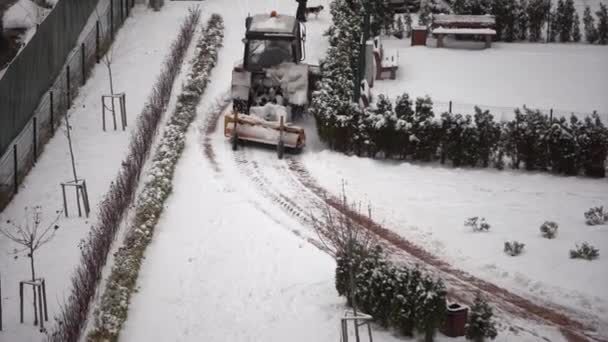 트랙터는 보행자 다리에 회전하는 밭으로 눈보라가 몰아칠 보도에 관리를 겨울철 — 비디오