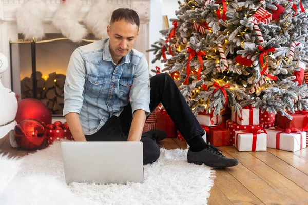 남자가 노트북 컴퓨터를 사용하고 비디오 전화로 이야기하고 온라인 쇼핑을 있습니다 — 스톡 사진