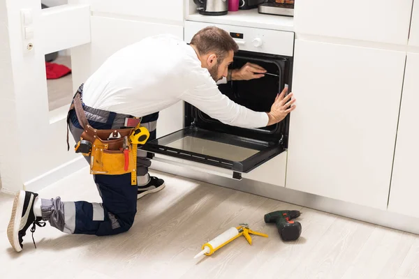 Junger Männlicher Techniker Repariert Ofen Küche — Stockfoto