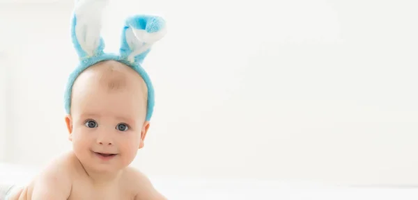 Stock image happy caucasian baby girl six months old wearing bunny ears headband.