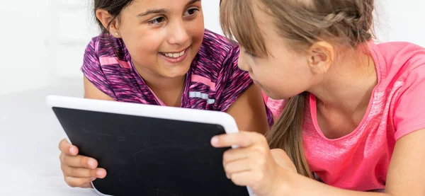 Dos Niñas Lindas Están Utilizando Una Tableta Digital Sonriendo Mientras —  Fotos de Stock