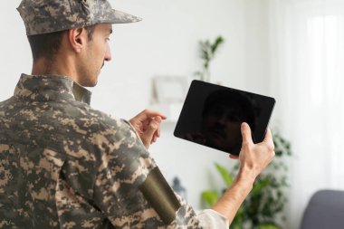 Erkek asker beyaz zemin üzerine tablet bilgisayar kullanarak. Askerlik Hizmeti.