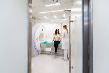 Modern hastane laboratuvarında bir hastaya tıbbi tomografi ya da MRI taraması yapın. Radyografi bölümünün içi. Beyaz odada teknolojik olarak gelişmiş ekipmanlar var. Manyetik rezonans tanılama makinesi.