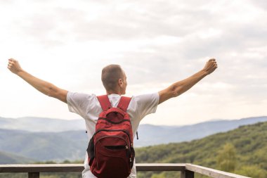 Sırt çantasıyla dağlarda gezen bir adam Seyahat yaşam tarzı başarı konsepti açık havada gezintiler spor hippi kıyafetleri.