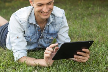 Yeşil Yapraklar Arkaplanında Tablet Bilgisayarlı Genç Adam