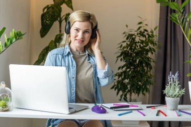 Pretty female student with cute smile keyboarding something on net-book while relaxing after lectures in University, beautiful happy woman working on laptop computer.