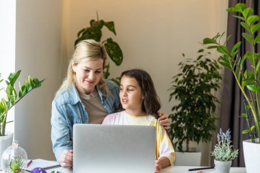 Güzel anne ve çocuk dizüstü bilgisayar ekranında app eğitim programı kullanarak mutfakta zaman geçirmek bakar, karikatürler seçin, çocuk pc kullanımını öğretmek, internet siber uzay konsepti ne kızı izlerken kontrol