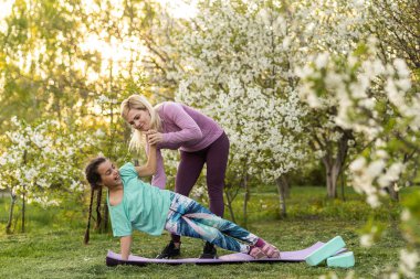 Anne ve kızı açık havada yoga, sağlıklı yaşam yapıyor