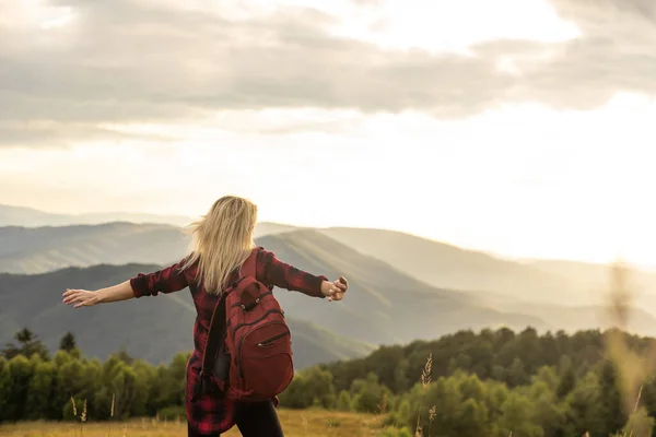 stock image Beautiful woman sitting on mountain top and contemplating landscape