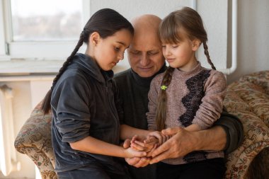 Yaşlı adamın elleri ve bir çocuğun elleri.