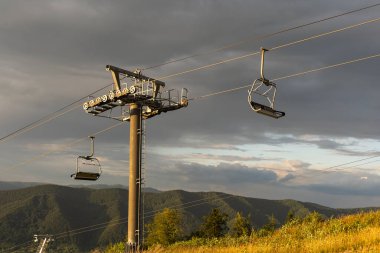 Dağlarda bir yaz gününde sarı dağ asansörü. Güneşli dağlarda eski bir kayak asansörü. Karpatlar, Ukrayna