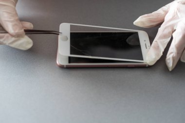 Yeni ekran bozuk ve kırılmış akıllı telefonu tamir etmeye ve değiştirmeye hazırlanan teknisyen veya mühendis masadaki akıllı telefonu kopyalama alanı ile.