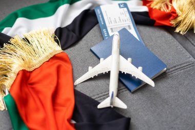Pasaport ve gri arka planda Birleşik Arap Emirlikleri bayrağı. Seyahat kavramı.