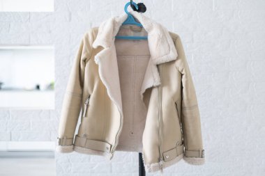 Askıda beyaz arka planda kadın ceketi.