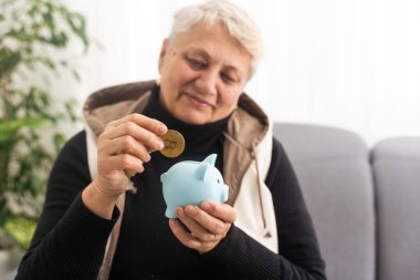 Para yönetimi konsepti. Yaşlı bir kadının elinde bir kumbara var..