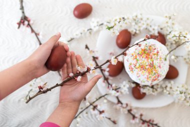 Paskalya için kırmızı yumurta, geleneksel Paskalya menüsü, boyanmış yumurtaları tutan eller..