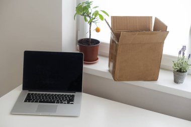 Başlangıç noktasında dizüstü bilgisayar, küçük işletme sahibi, uluslararası paket teslimat konsepti, küresel alımlar ulaşım işi, karton kutular yığını, çevrimiçi satış, e-ticaret