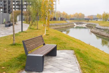 Kentsel alanda sonbahar ağaçları. Konut ve sanayi binalarının çatıları çok renkli yaprakların taçlarında gömülüdür..