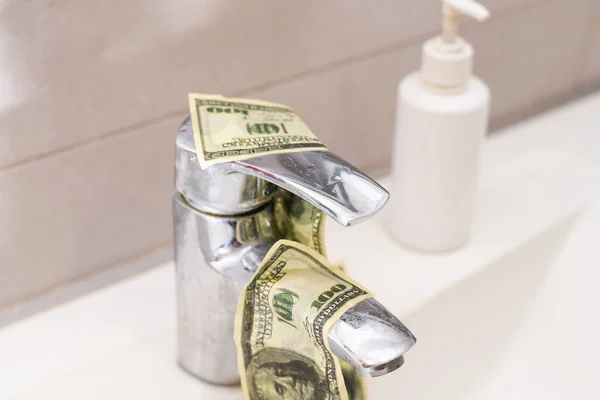 Cash Money Going Down Sink Drain Isolated on White Background.
