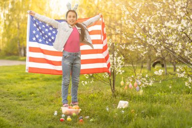 Paskalya 'da çiçek açan bahçede Amerikan bayrağıyla genç bir kız..