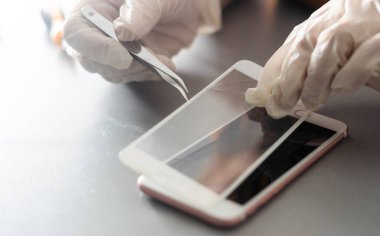 Bir insan akıllı telefona koruyucu cam ya da film yerleştirir. Boşluğu kopyala