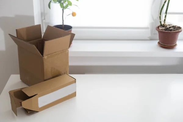 empty open cardboard box on wooden surface with empty space.