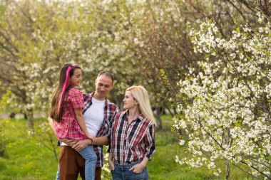 Çiçek çiftliğinde oynayan bir kızla mutlu bir aile..