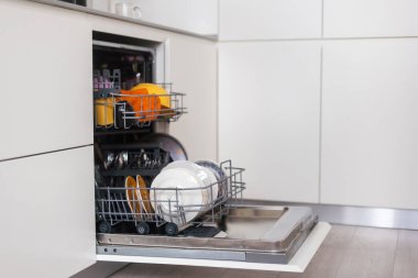 Dahili bulaşık makinesinin kapısı açık. Entegre cihazlı mutfak. Tabaklar ve bulaşıklar bulaşık makinesinde..