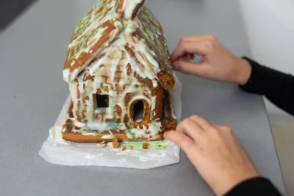 Kids with gingerbread house, A teenage girl is eating a gingerbread house.