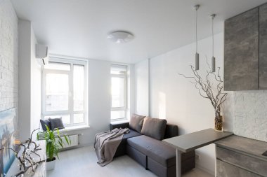 Gri kanepesi ve iki metal sehpası olan şık bir oturma odası..