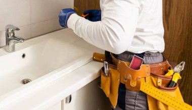 Erkekler banyoda lavabo tamir ediyorlar..