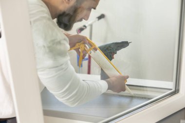 servis elemanı tornavidayla pencere kuruyor.